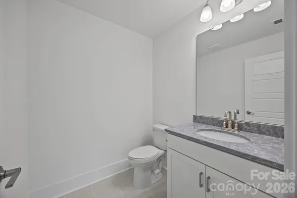 a bathroom with a granite countertop sink a toilet and a mirror
