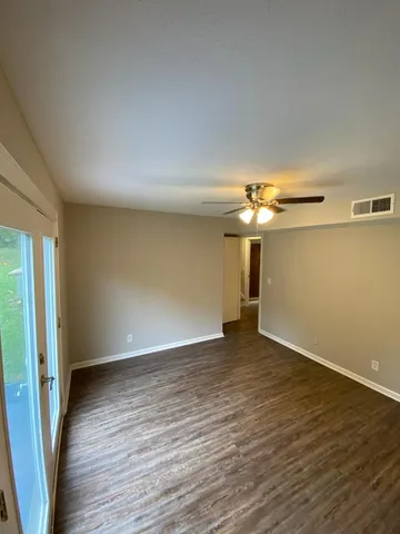 a view of empty room with wooden floor
