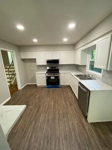 a kitchen with stainless steel appliances granite countertop a stove a sink and a refrigerator