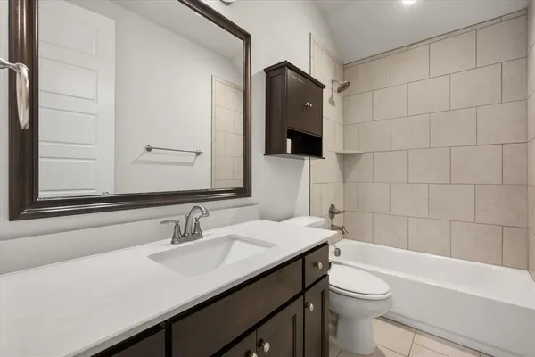 a bathroom with a sink a toilet a mirror and bathtub