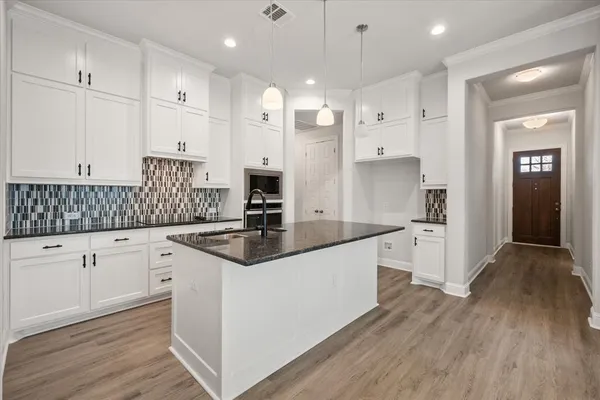 a kitchen with granite countertop white cabinets and white appliances