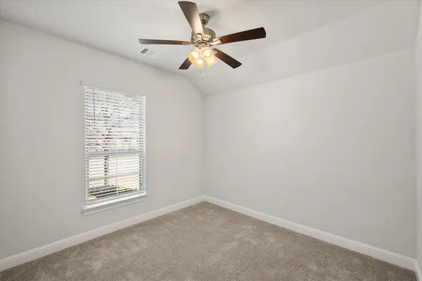 an empty room with a window and a fan