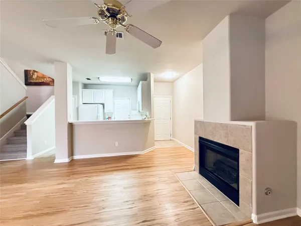 a view of an empty room with kitchen and a window