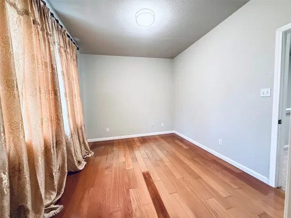 an empty room with wooden floor and a window