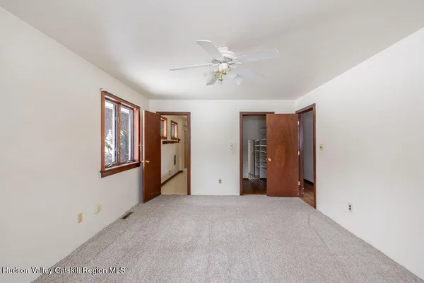 an empty room with a window and a ceiling fan