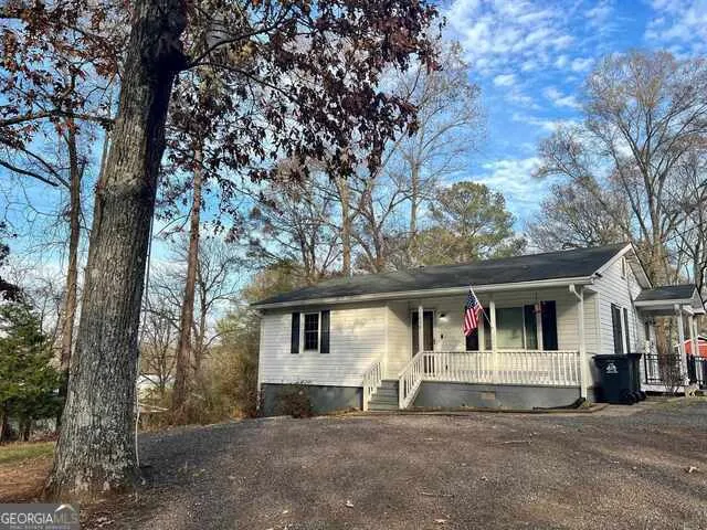 a front view of a house with a large tree