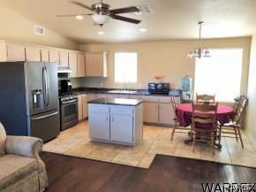 737 Heber Road Golden Valley, AZ 86413 - Photo 3 of 26 a kitchen with stainless steel appliances granite countertop a stove a refrigerator a sink a dining table and chairs with wooden floor