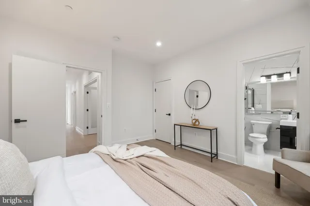 a bedroom with a bed a chandelier and mirror
