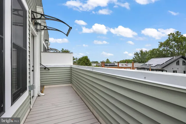 a view of a balcony with two chairs and a potted plant
