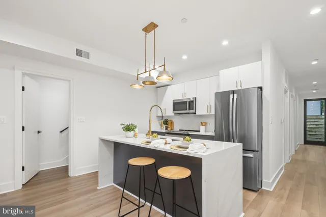 a kitchen with kitchen island a sink appliances and cabinets
