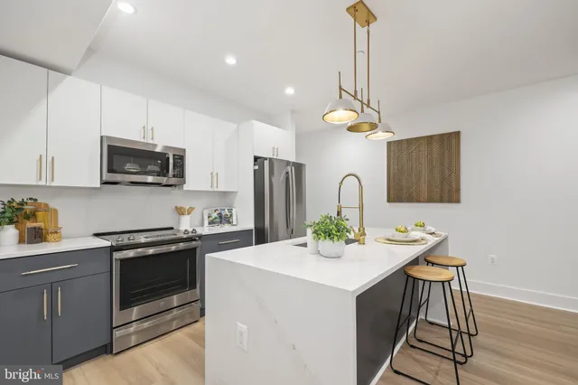 a kitchen with stainless steel appliances a sink stove and microwave