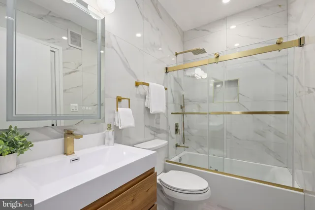 a bathroom with a sink vanity mirror and toilet