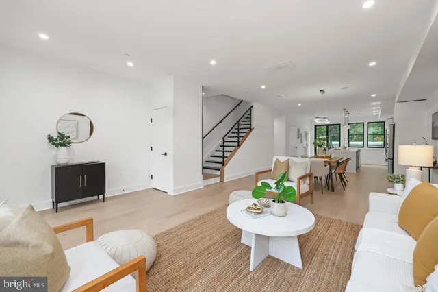a living room with furniture a dining table and a potted plant