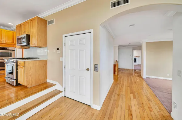 an empty room with chandelier fan and windows