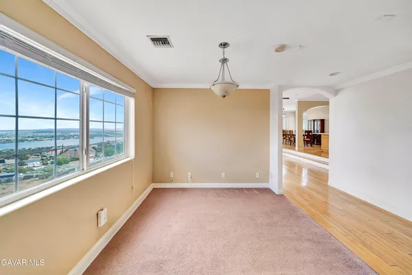 an empty room with windows and chandelier fan