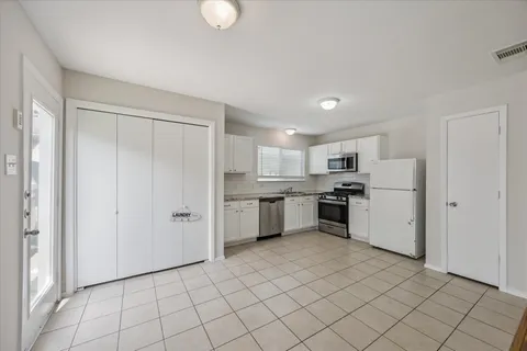 a kitchen with white cabinets and white appliances