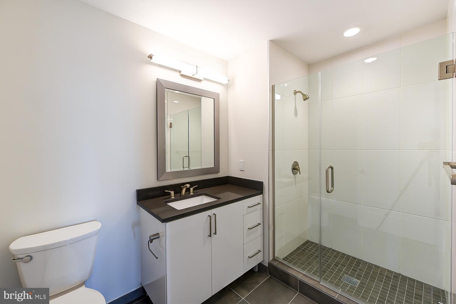 901 H Street Northeast, Unit AT D Washington, DC 20002 - Photo 18 of 82 a bathroom with a granite countertop sink and a toilet