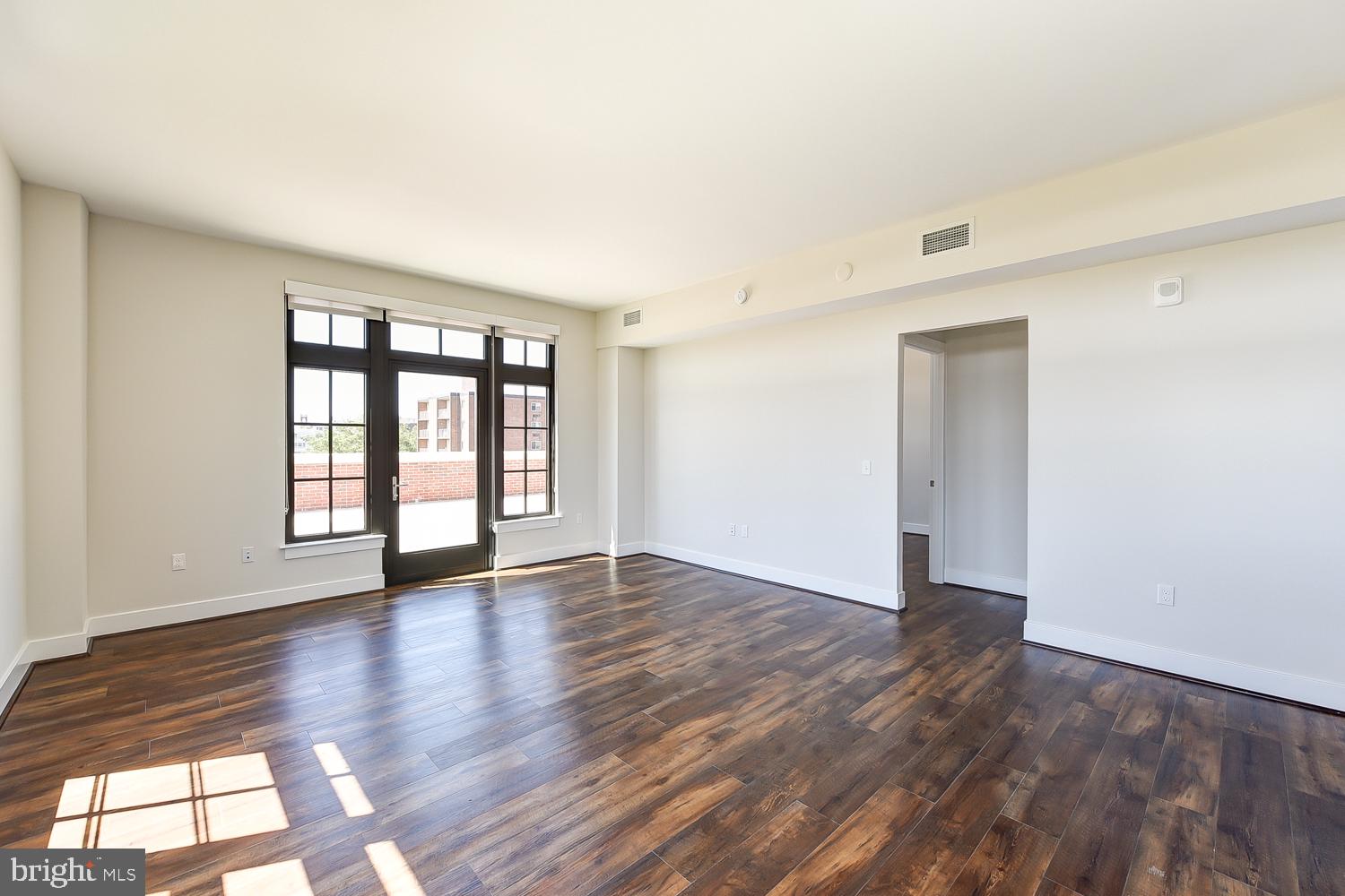 901 H Street Northeast, Unit AT D Washington, DC 20002 - Photo 9 of 82 a view of an empty room with wooden floor and a window