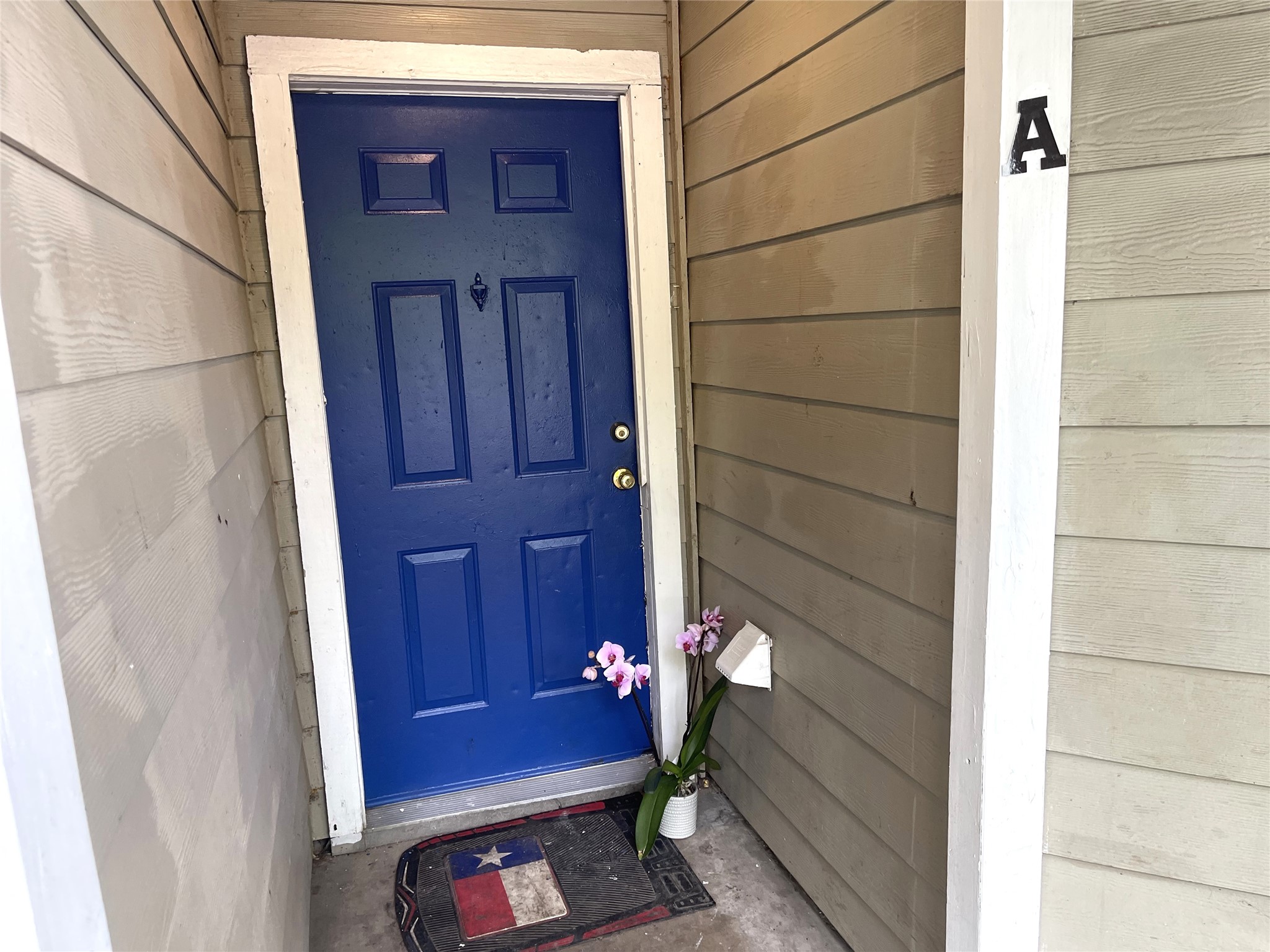 1902 West Loop, Unit B1 Austin, TX 78758 - Photo 2 of 23 Entrance featuring a paneled door with bright blue finish, white trim, and gold-tone hardware