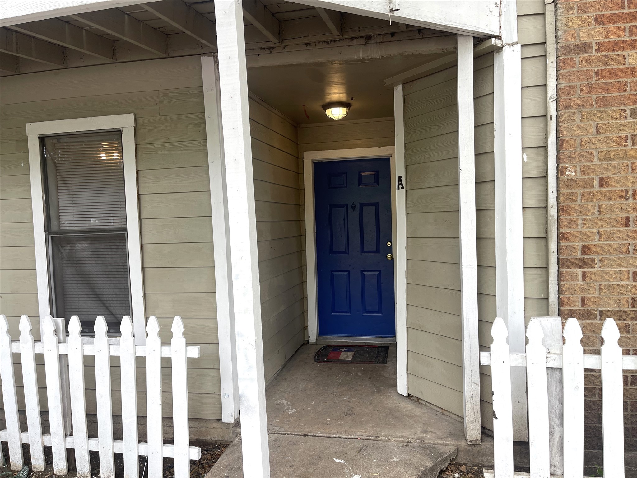 1902 West Loop, Unit B1 Austin, TX 78758 - Photo 22 of 23 Entryway featuring a paneled blue door, overhead lighting fixture, and concrete porch