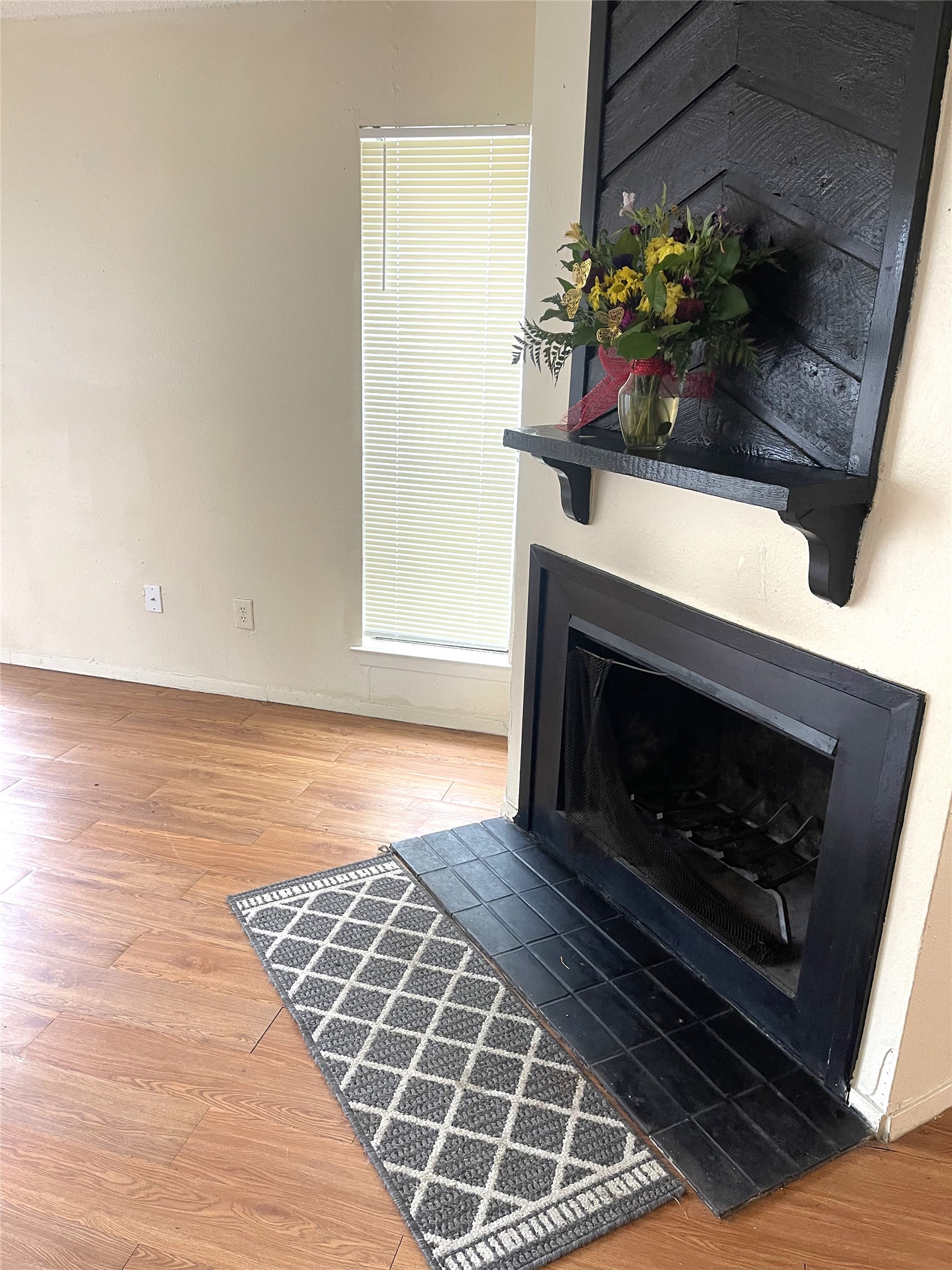 1902 West Loop, Unit B1 Austin, TX 78758 - Photo 7 of 23 Wood-finish flooring throughout, featuring a fireplace with a black metal insert