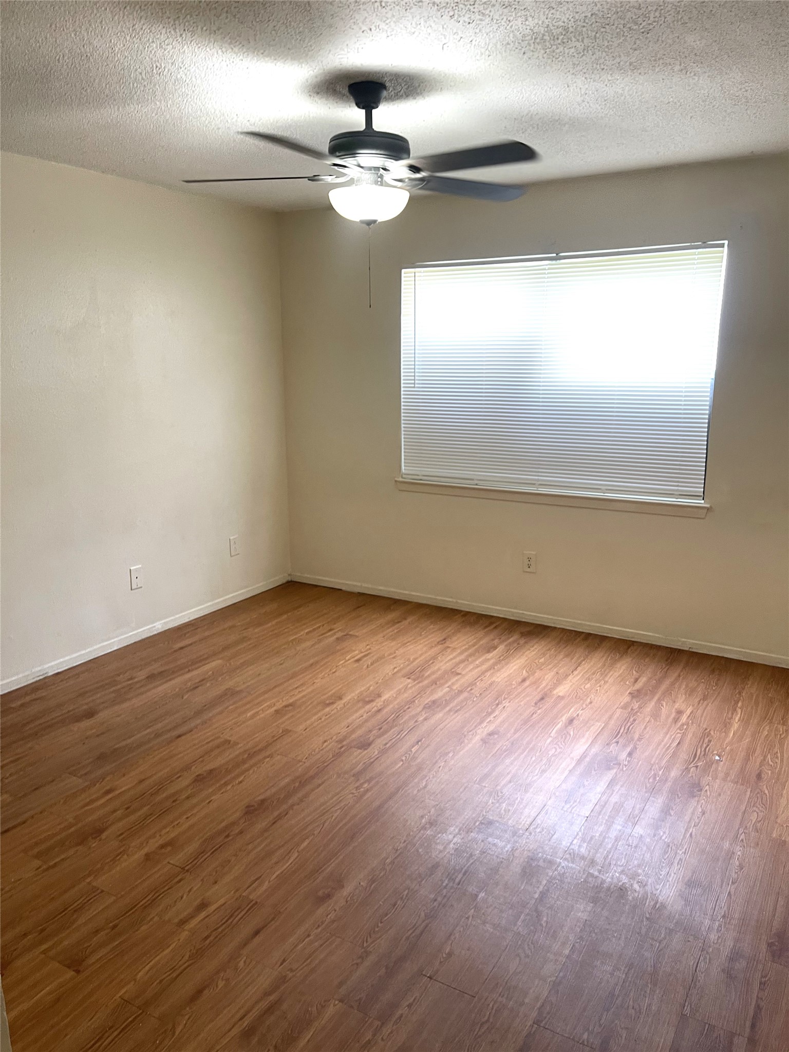 1902 West Loop, Unit B1 Austin, TX 78758 - Photo 9 of 23 Room featuring wood-finish flooring, light-colored walls, and a ceiling fan with integrated lighting