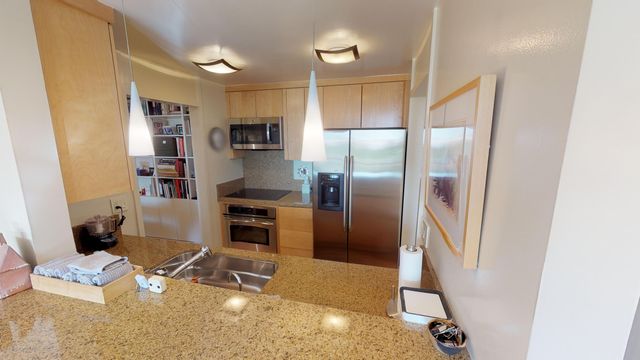 a kitchen with a refrigerator and a stove top oven