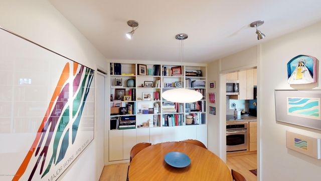 a view of a living room with furniture and a book shelf