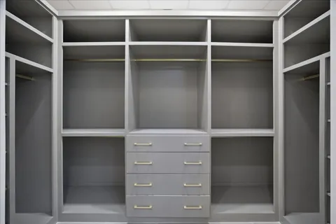 a large white kitchen with kitchen island a sink stainless steel appliances and cabinets