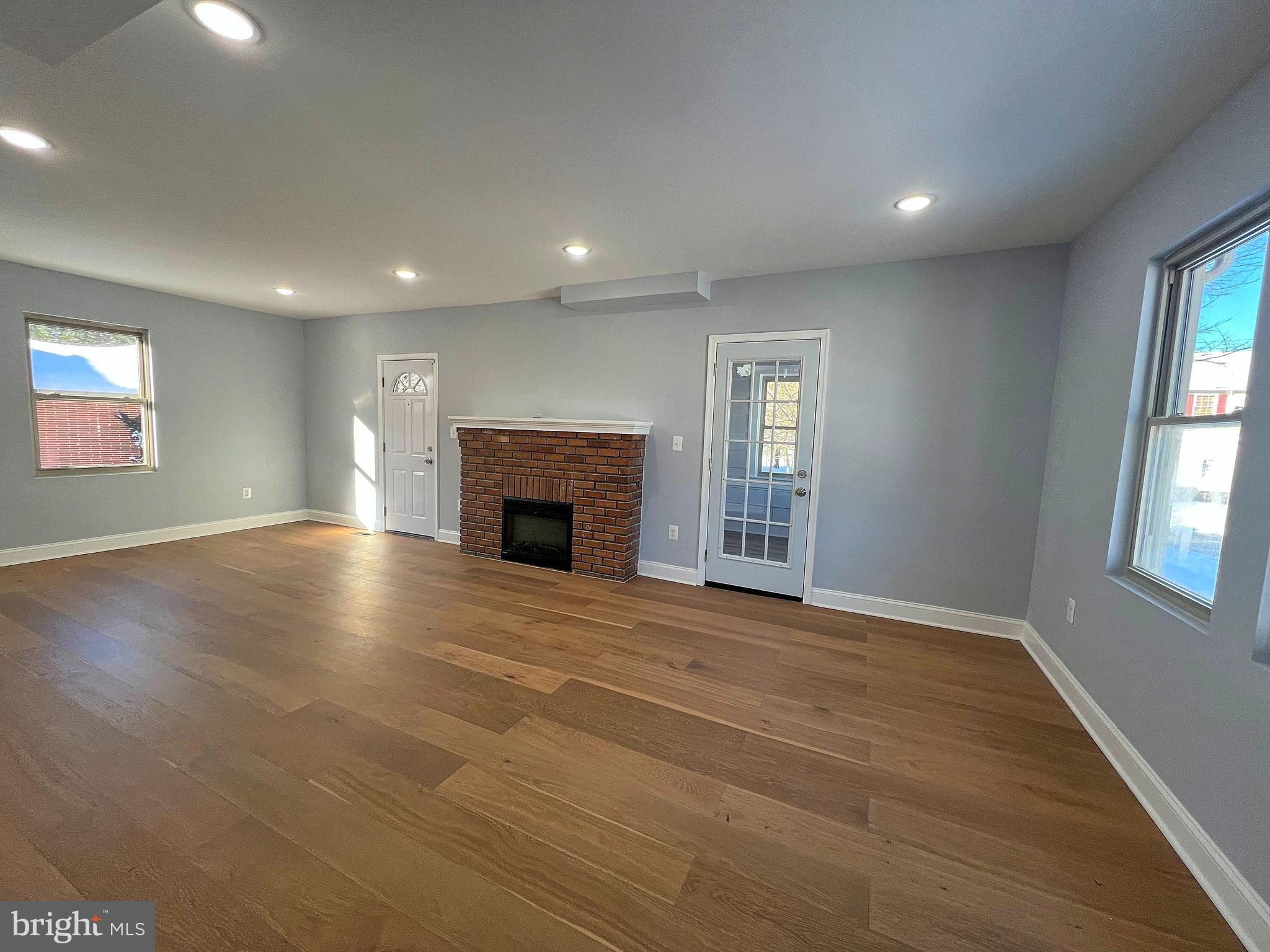 4311 Miami Place Baltimore, MD 21207 - Photo 4 of 26 an empty room with windows and fireplace