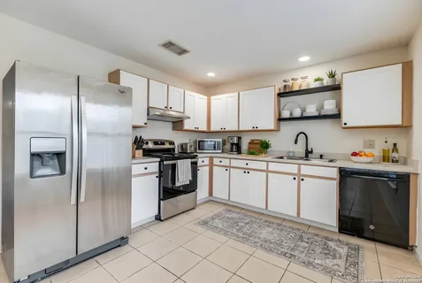 a kitchen with granite countertop stainless steel appliances and white cabinets