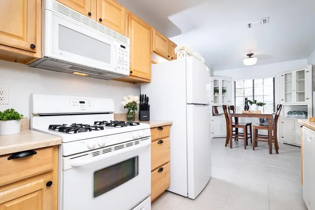 a kitchen with stainless steel appliances granite countertop white cabinets and a stove top oven