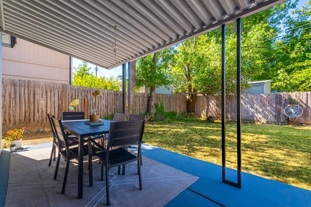 a view of a patio with a table chairs and a backyard