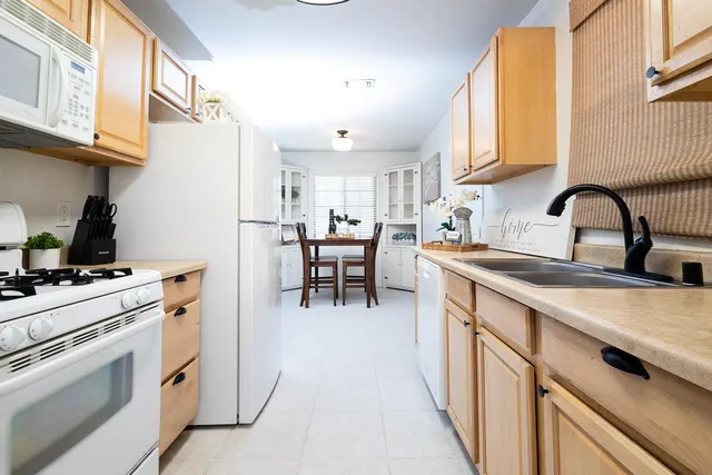a kitchen with appliances a sink and cabinets