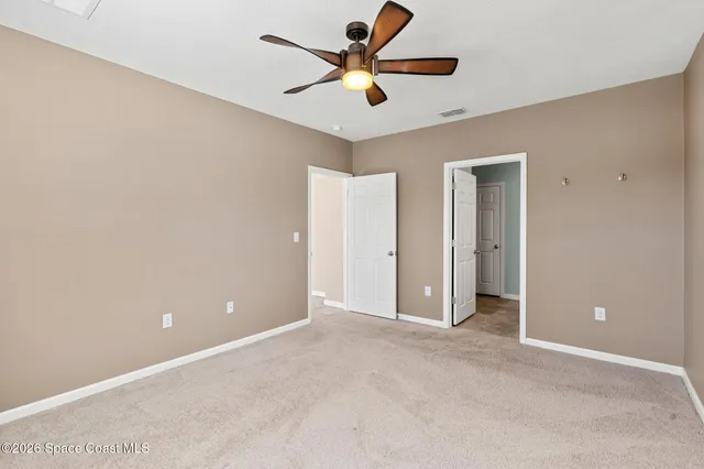 an empty room and chandelier fan