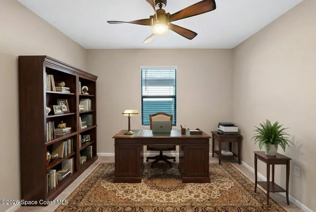 an empty room with a window and a ceiling fan
