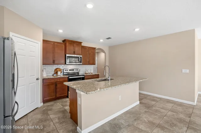a kitchen with a sink a stove top oven and refrigerator