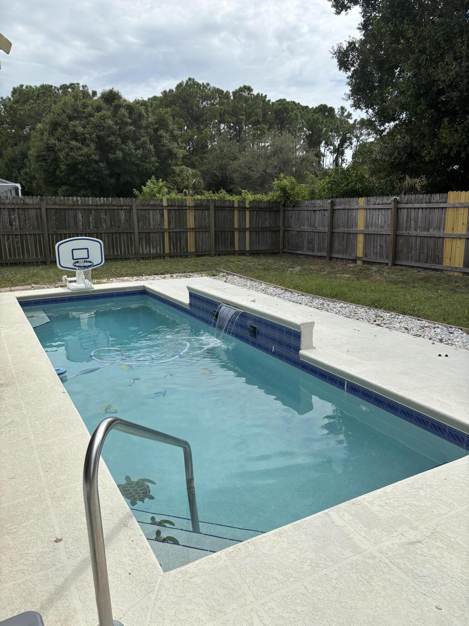 3718 Southwest Masilunas Street Port St. Lucie, FL 34953 - Photo 19 of 20 a view of a swimming pool with a yard