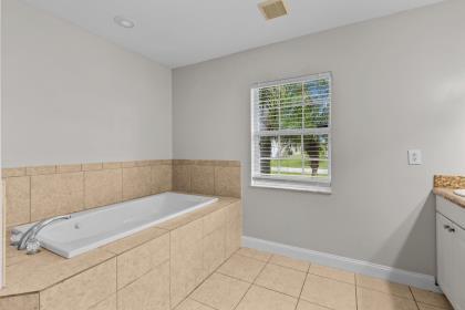3718 Southwest Masilunas Street Port St. Lucie, FL 34953 - Photo 9 of 20 a bathroom with a bathtub and window