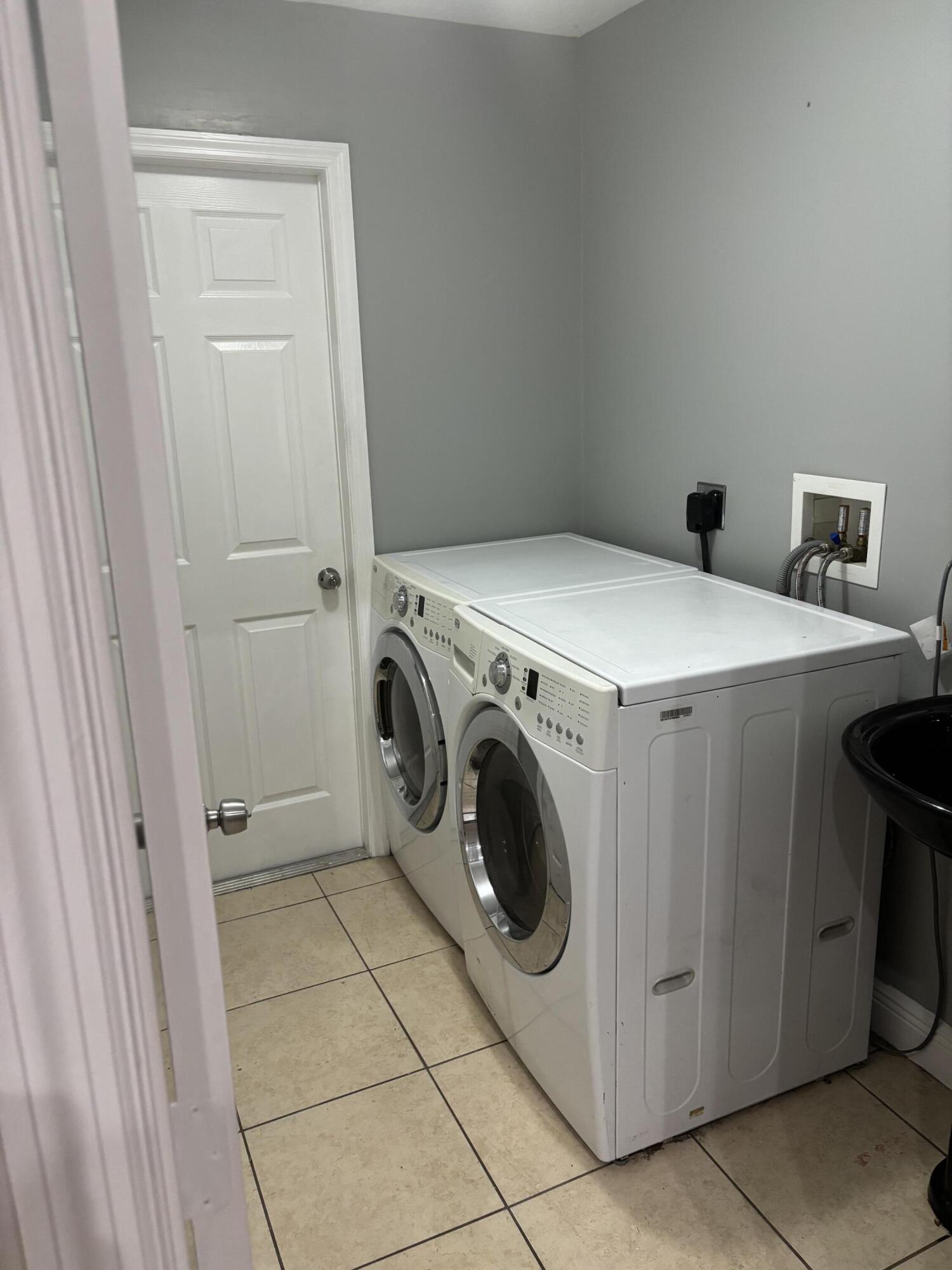 3718 Southwest Masilunas Street Port St. Lucie, FL 34953 - Photo 10 of 20 a utility room with dryer and washer