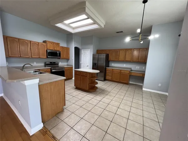 a kitchen with stainless steel appliances granite countertop a sink and a refrigerator