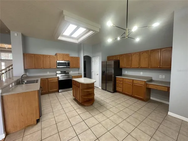 a kitchen with granite countertop a sink counter top space appliances and cabinets