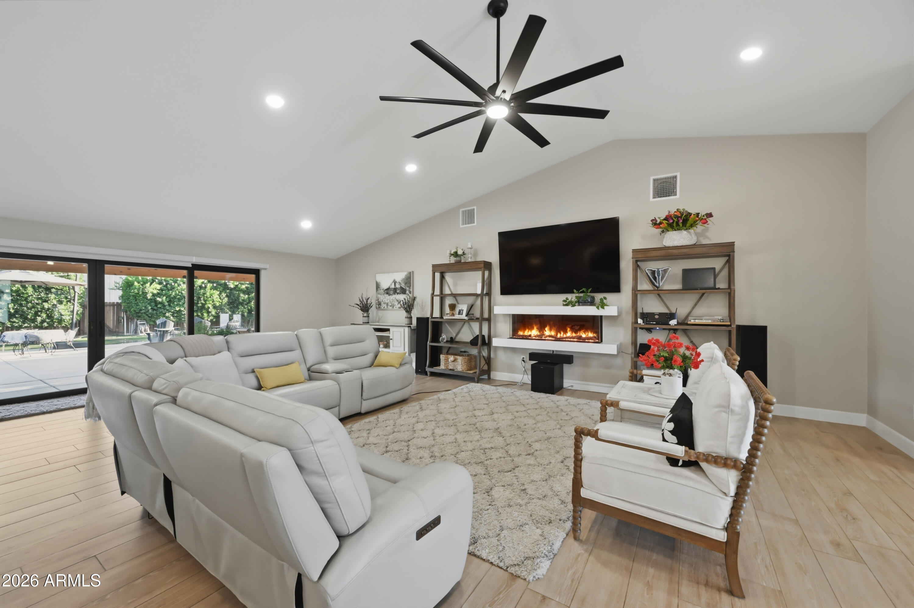 5213 West Dobbins Road Laveen, AZ 85339 - Photo 22 of 69 a living room with furniture a flat screen tv and a fireplace