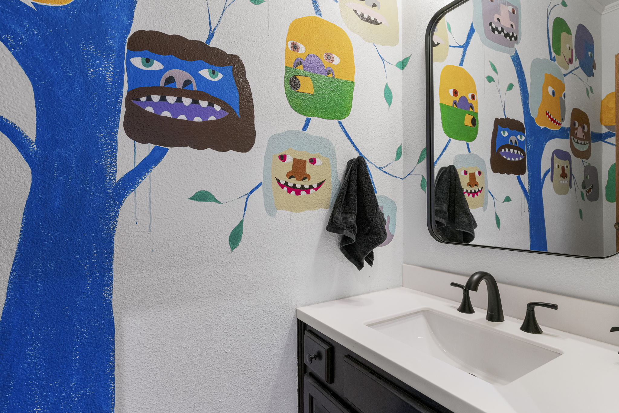 400 Hackberry Street Lockhart, TX 78644 - Photo 25 of 40 Bold, whimsical wall art brings a playful touch to this well-appointed bathroom vanity.
