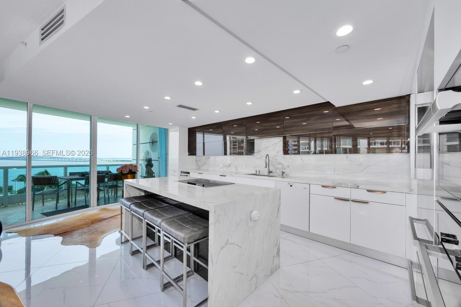 2127 Brickell Avenue, Unit 801 Miami, FL 33129 - Photo 13 of 38 a kitchen with a sink stainless steel appliances dining table and chairs