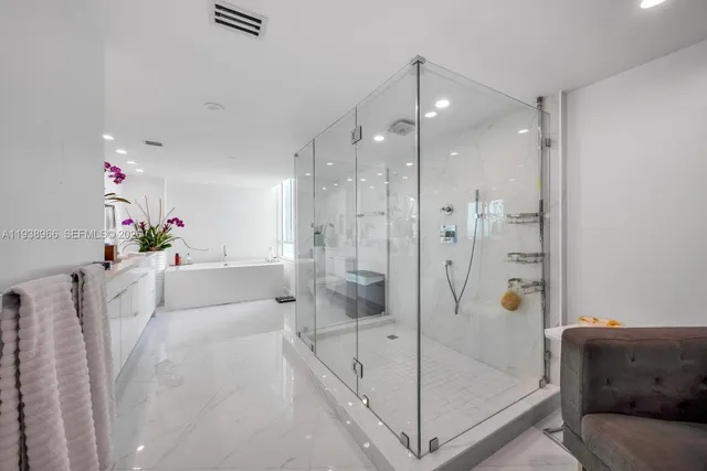 a white bath tub sitting next to a shower