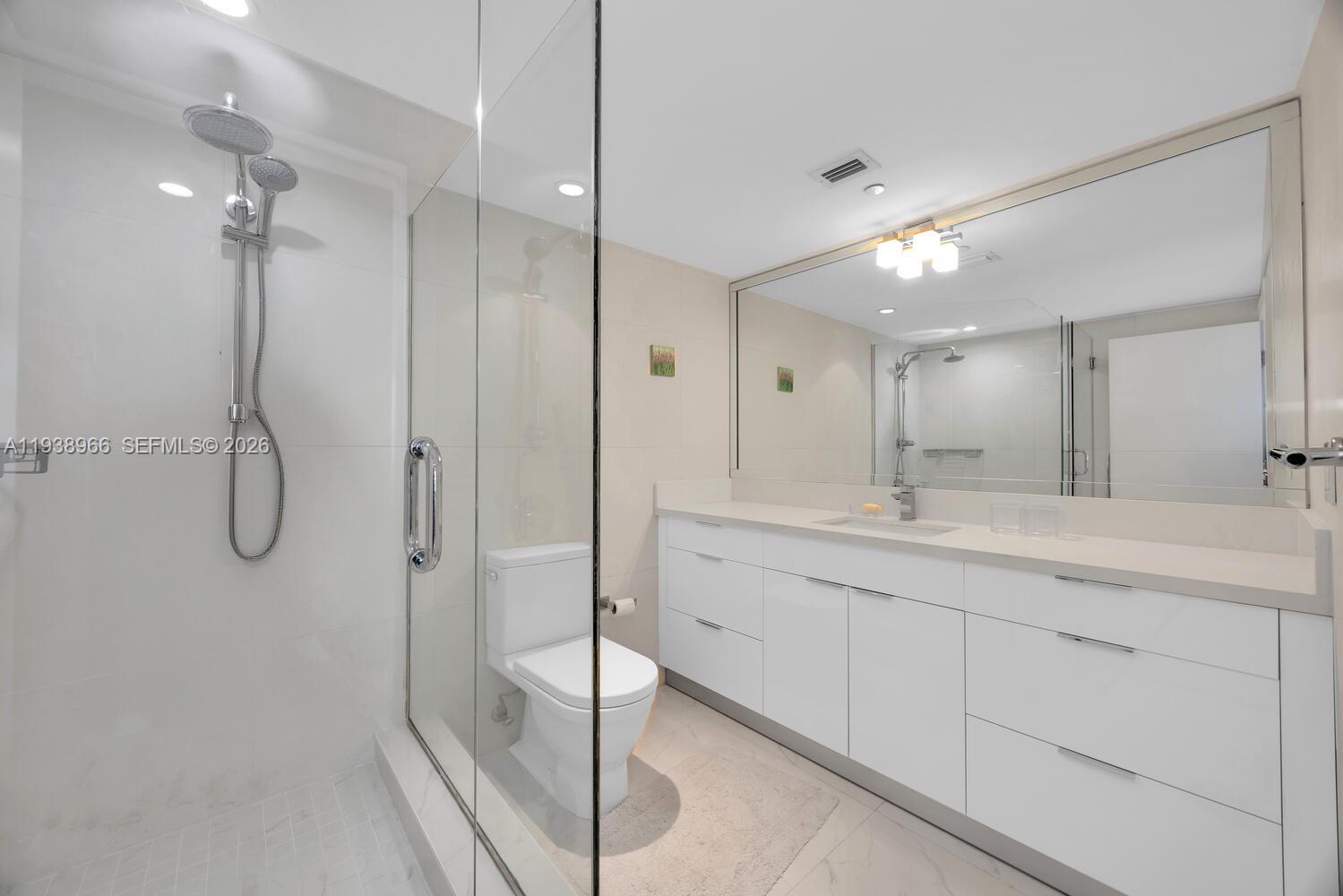 2127 Brickell Avenue, Unit 801 Miami, FL 33129 - Photo 22 of 38 a bathroom with a double vanity sink mirror and shower