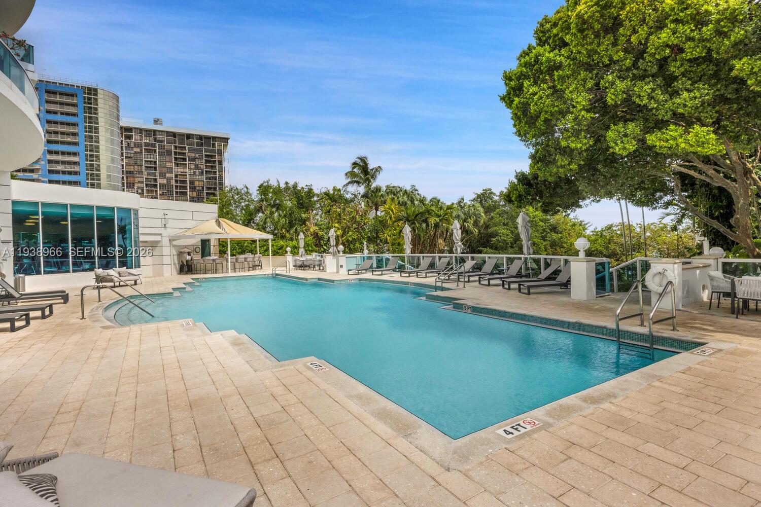 2127 Brickell Avenue, Unit 801 Miami, FL 33129 - Photo 32 of 38 a view of a swimming pool with a lawn chairs
