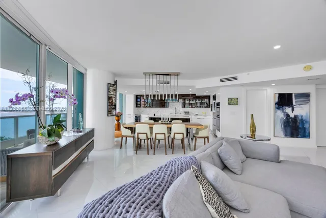 a living room with furniture a dining table and a potted plant