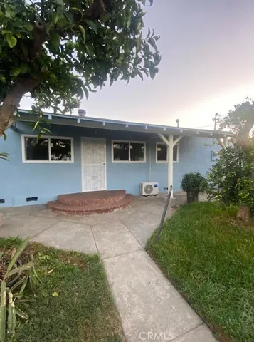 a front view of house with yard and trees around